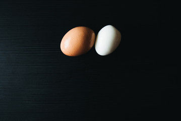 Fresh hard boiled eggs with shell beside on wooden  black board (Selective Focus)