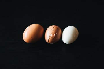 Fresh hard boiled eggs with shell beside on wooden  black board (Selective Focus)