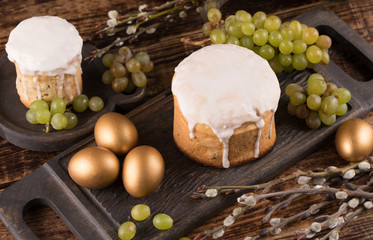 Easter cake and colorful eggs on festive Easter table. Golden eggs and traditional Easter cake on a wooden background.