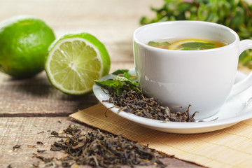 cup of black tea with mint leaves on a wooden table