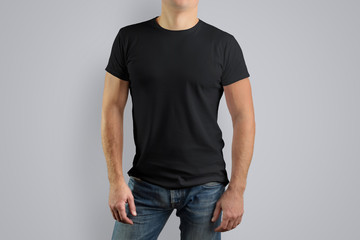Man in a black t-shirt is isolated on a gray background