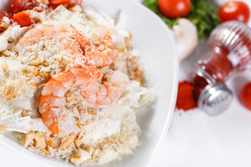 Caesar Salad with Royal shrimps . Comprises iceberg lettuce Leaf and croutons dressed with parmesan cheese. White light background