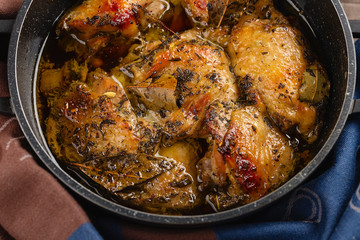 Closeup of сhicken baked in herbs in baking pan