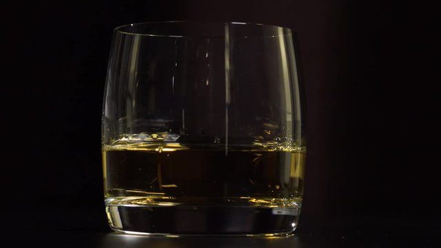 Closeup on a glass of whiskey - dark background