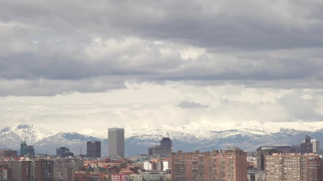 Panoramic view to Madrid, the skyscrapers and television tower El Pirul. Cityscape, cloudy day over Madrid, background snowy mountain