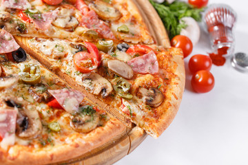 Italian kitchen and cooking concept. Hot tasty sliced with ham, sausage, jalapenos, mushrooms, tomato. Eat delivery concept.