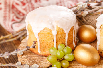 Easter cake and colorful eggs on festive Easter table. Golden eggs and traditional Easter cake on a wooden background.