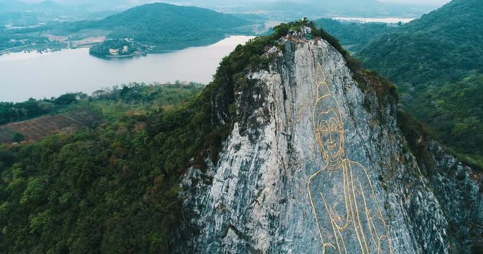 Aerial drone view of carved buddha image from gold on the cliff at Khao Chee chan, Pattaya, Thailand