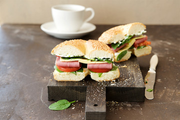 Bagel with beef, vegetables, salad and cheese. Wooden background
