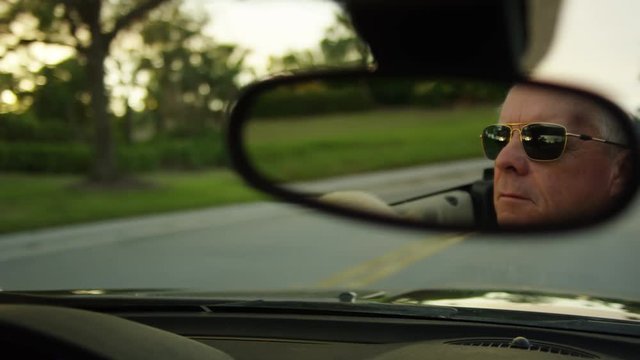 Closeup On A Rearview Mirror's Reflection Of Carefree Senior Man Driving His Luxury Convertible, His Dog In His Lap - Shot On Red Scarlet-W Dragon In 4K/ Slow Motion