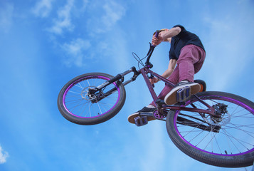 Naklejka premium young man performs stunts on a bike, jumping from a great height in interesnyh angles