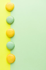colorful macaroons on green and yellow background