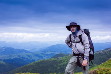 Fototapeta na wymiar tourist with bag on the background majestic mountains