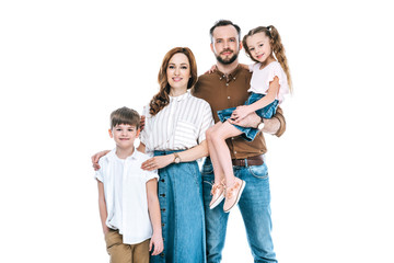 Obraz premium happy family with two kids standing together and smiling at camera isolated on white