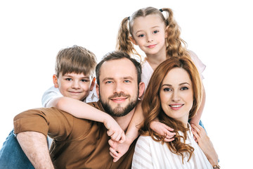 happy family with two children smiling at camera isolated on white