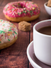 Donuts and coffee on wooden table. Top view with copy space