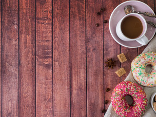 Donuts and coffee on wooden table. Top view with copy space