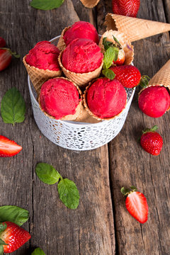Ice cream, Strawberry scoop in cone on wooden table. 