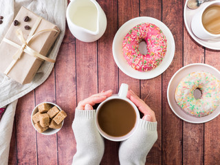 Donuts and coffee on wooden table. Top view with copy space