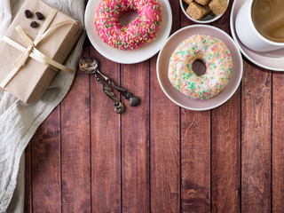 Donuts and coffee on wooden table. Top view with copy space