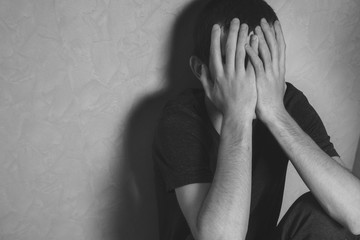 The man closes his face with his hands . The concept of depression, crisis and problems in life