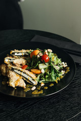 Fresh green salad on black plate