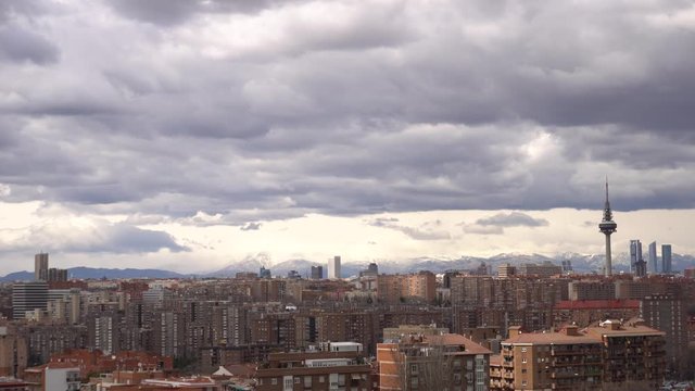 View to Madrid, the skyscrapers and television tower El Pirul. Cityscape, cloudy day over Madrid, background snowy mountain