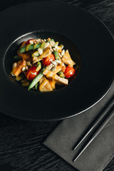 Fresh healthy dinner with seeds and vegetables on black plate