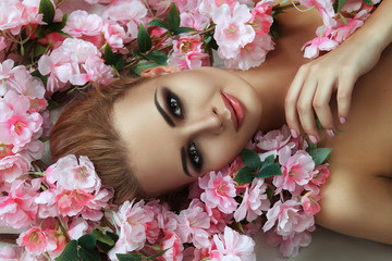 Beautiful blondie model is emotionally posing with flowers