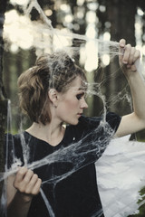 The young model is posing as a fairy in a spiderweb