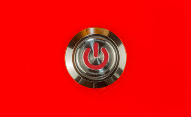 interrupteur bouton poussoir métal sur fond rouge 