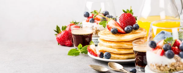 Fotobehang Breakfast composition with fresh pancakes and berries on light gray concrete background. Healthy food concept with copy space. Banner. © Iryna Melnyk
