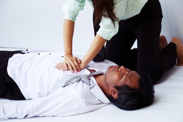 Woman is saving man's life by doing CPR helping man to breath