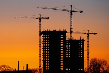 Construction of high-rise buildings against the background of sunset.