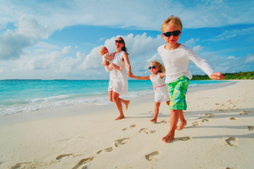 mother with kids play run on tropical beach