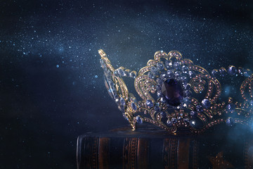 low key image of beautiful queen/king crown over wooden table. vintage filtered. fantasy medieval...