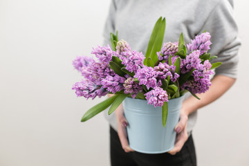 Bouquet of Beautiful violet and lilac hyacinths. Spring flowers in vase in woman hand. bulbous plant. Horizontal photo
