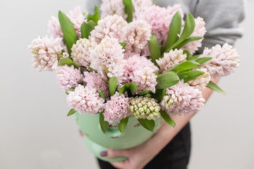 Bouquet of Beautiful pink hyacinths. Spring flowers in vase in woman hand. bulbous plant. Horizontal photo