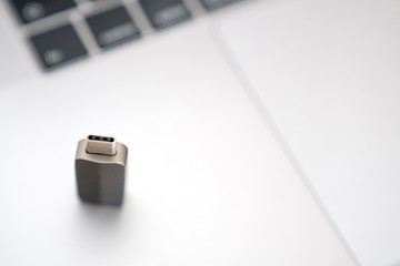 Gray Thunderbolt Adapter on the gray keyboard. Digital technologies and objects.