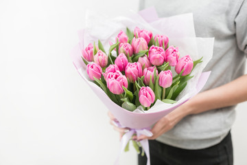 Tulips of pink color in woman hand. Big buds. Floral natural backdrop. Unusual flowers, unlike the others. Shallow focus. Wallpaper, Horizontal photo