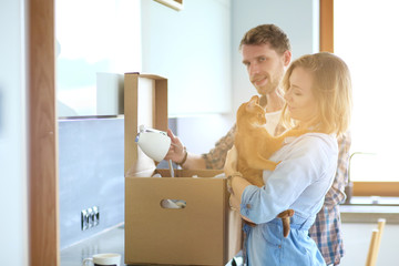 Young couple carrying big cardboard box at new home.Moving house. Young couple