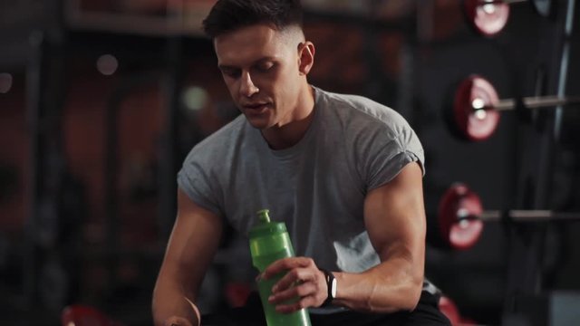 Portrait young man use phone drink water in gym sportsman sport fitness internet face technology fit lifestyle male workout athlete sportswear networking body exercise healthy mobile smartphone