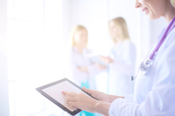 portrait of a young female doctor, with aipads in hand, in a medical office