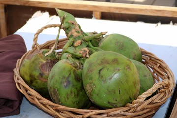 Green coconuts in a basket on the market