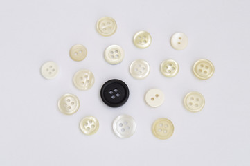 group of white buttons and a black button