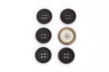 black buttons and one white on white background
