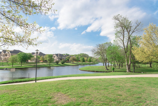 Typical Lakeside New-established Community With Newly Built Detached Single-family Homes. Cloud Blue Sky Reflection Near Urban Park With Walking Path In Suburban Irving, Texas, USA