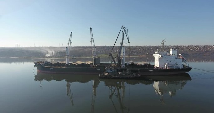 Aerial view of dry cargo ship or freighter loading dredger landscape morning river, Central Europe
