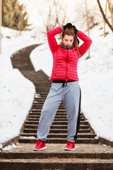 Woman wearing sportswear exercising outside during winter