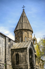 View of the dome and the bell tower from the corner of the portal of the Church of San Marine through the Park in the city of Ashtarak